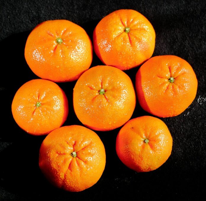 a group of oranges sitting on top of a black surface