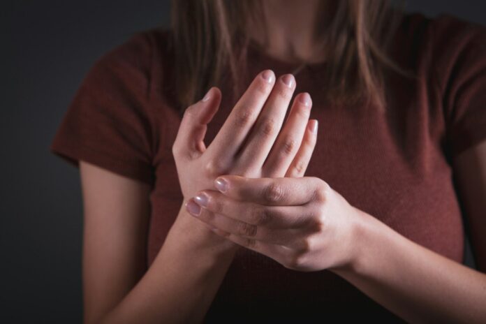 Woman holding her hand with pain.