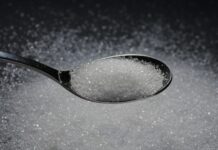 脳の老化は食事で変わる──しかし高糖質の影響は簡単に消えない a spoon filled with sugar on top of a table