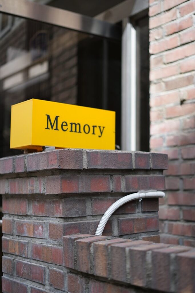 A yellow sign on brick says "memory."